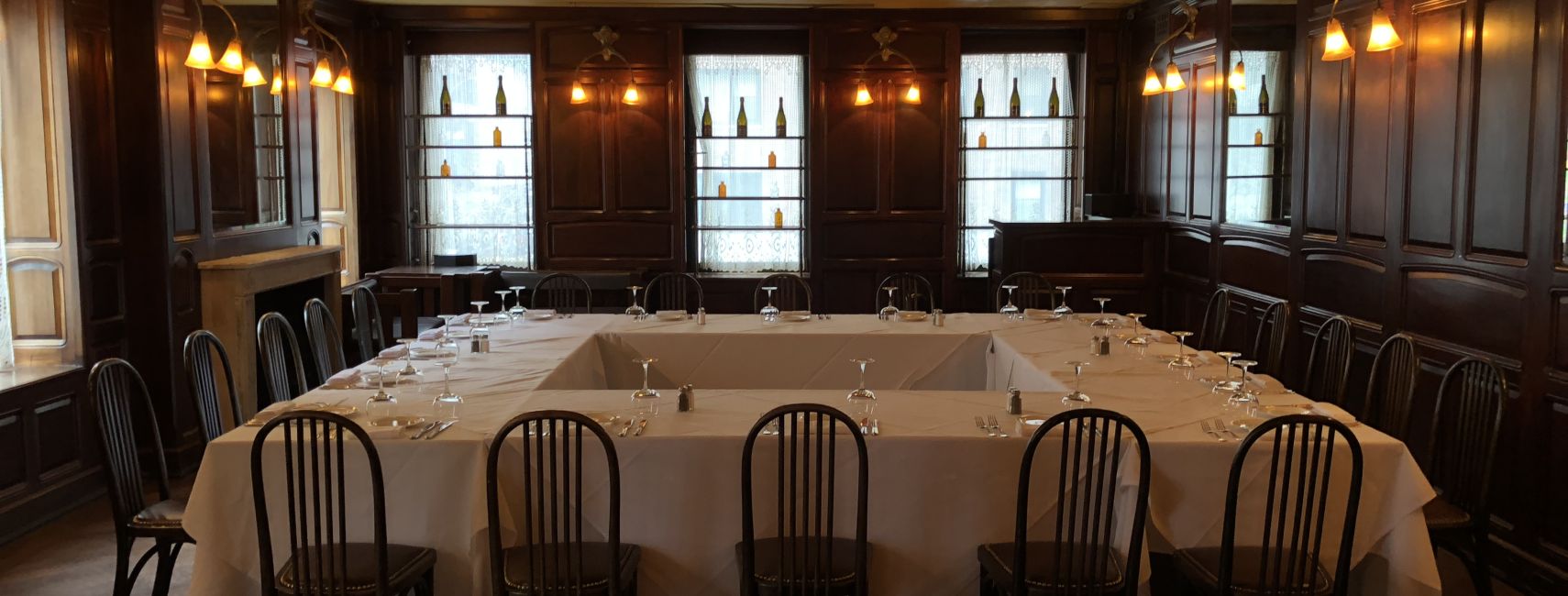 Restaurant chic, lumière tamisée. Une table élégamment dressée pour un dîner festif, prête à accueillir des invités.